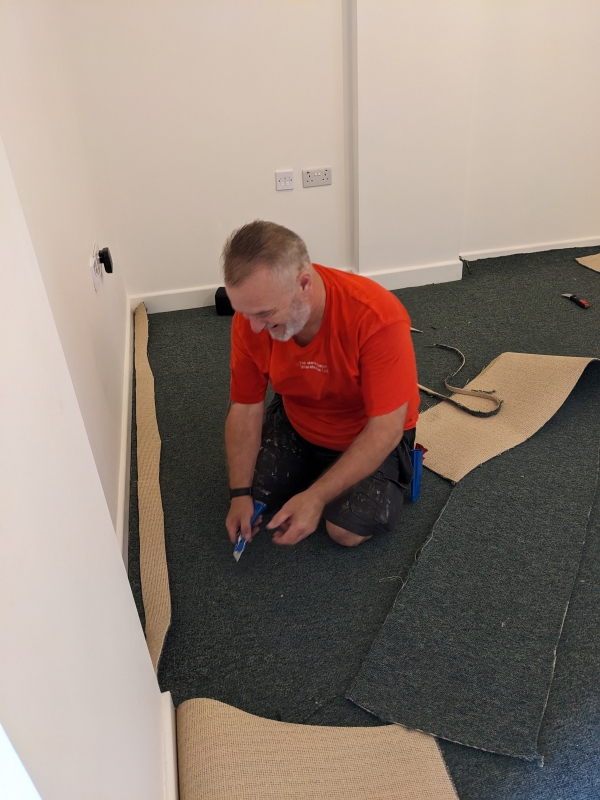 Interior showing carpet being laid in the studio.